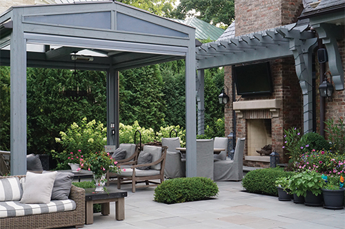 Winnetka Couple Transforms Garden Into Stunning Outdoor Living Space: A large pergola divides the patio into distinctive spaces.