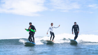 Surfers surfing together in the ocean, photo by Ryan Chachi Craig