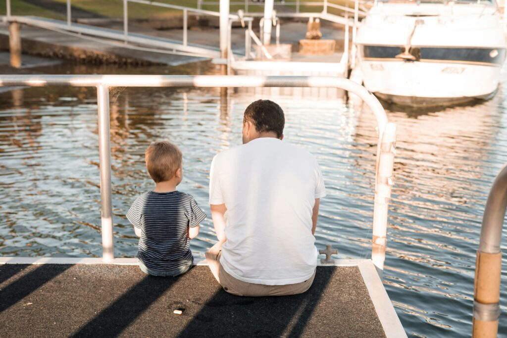 Father sitting with young son on dock
