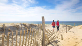 Couple walk along beach, Cape Cod