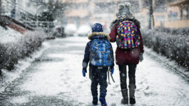 Brother and sister going to school on winter day