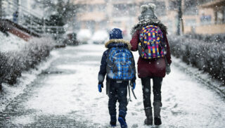 Brother and sister going to school on winter day