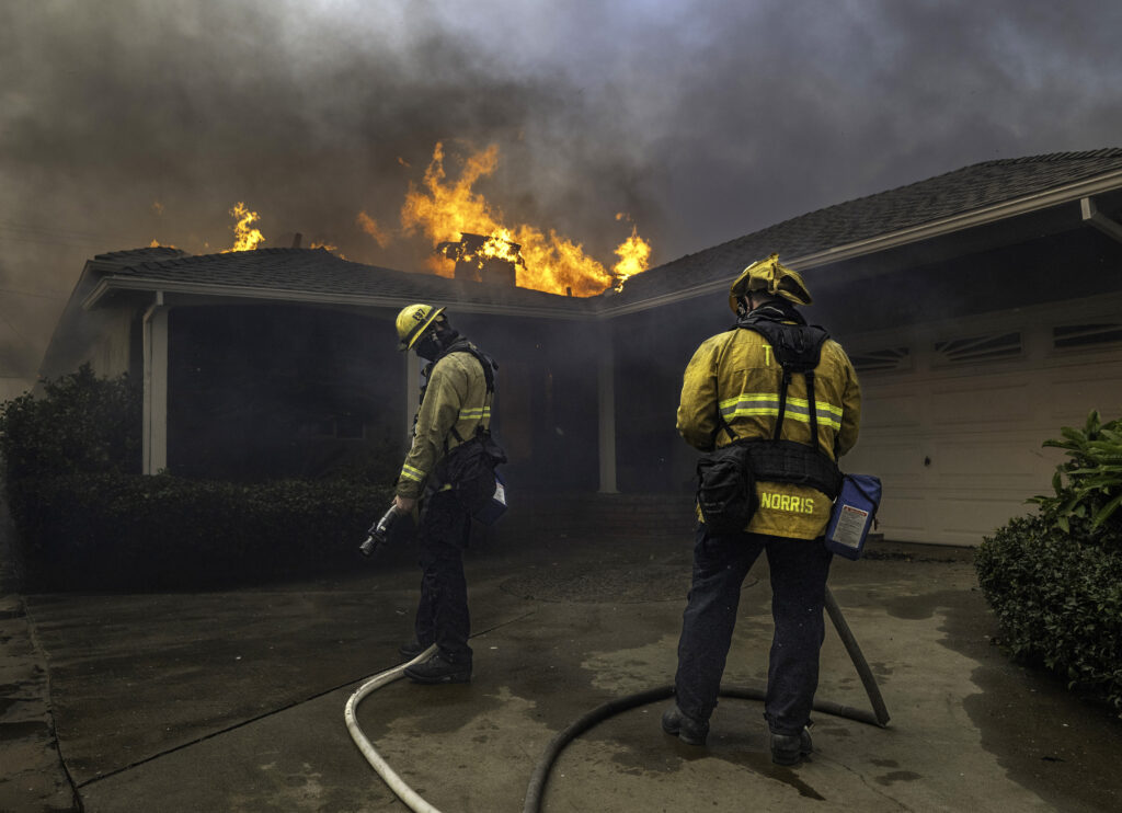 January 8, 2024:  Firefighters wait for more water before continuing to fight a house fires in Pacific Palisades during the Palisades Fire. 