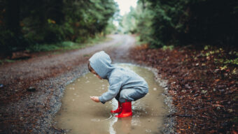 Kid playing in mud puddle