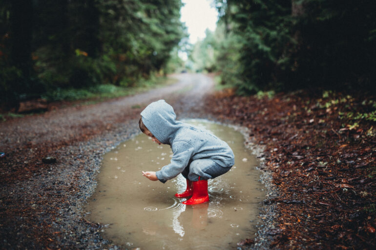 Kid playing in mud puddle