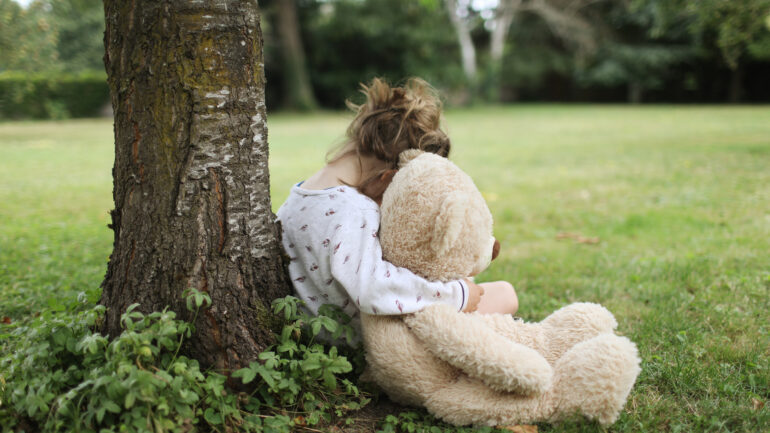 grieving child with teddy bear