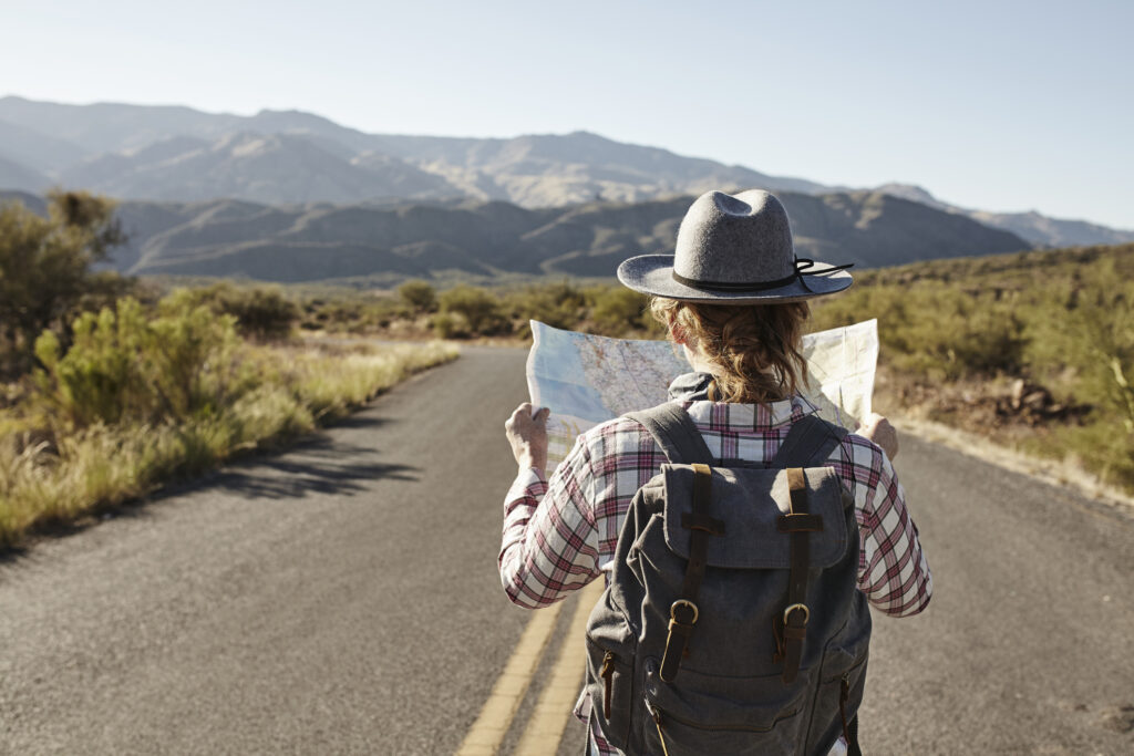 woman looking at map travel open road
