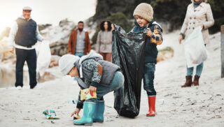 Multigenerational family cleaning up the beach