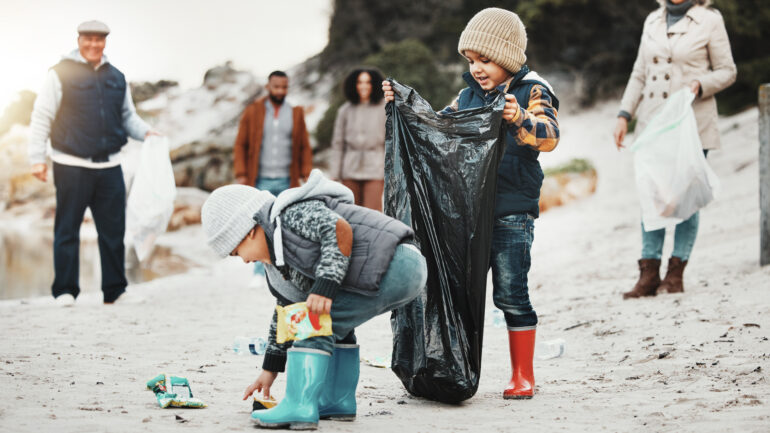Multigenerational family cleaning up the beach