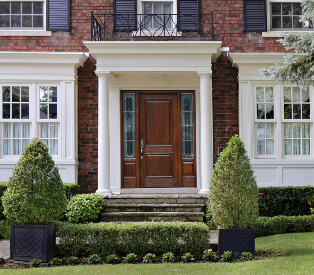 Ontario, Canada - July 26, 2025: Portico entrance of house with elegant wood grain front door