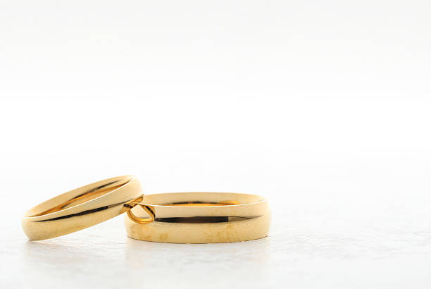 Beautiful golden wedding ring on white table, space for text