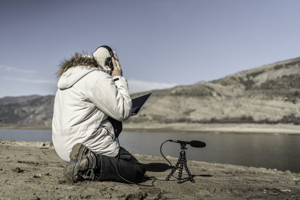 Sustainability practices. Man does field-based studies using AI driven ecoacoustic approaches in bioacoustics research.
